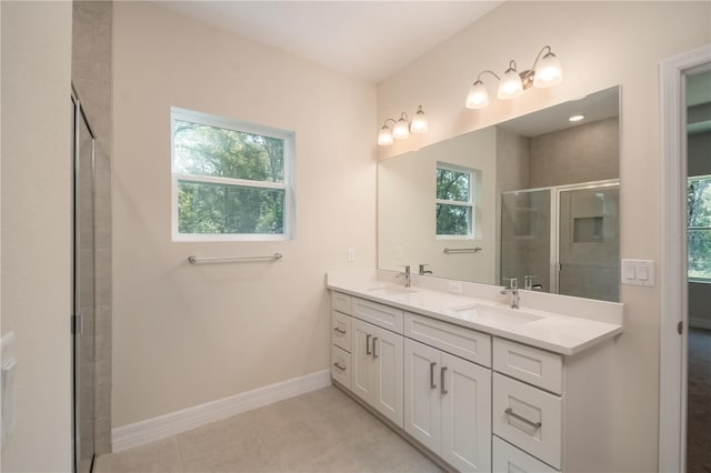 bathroom featuring double vanity, baseboards, a sink, and tile patterned floors