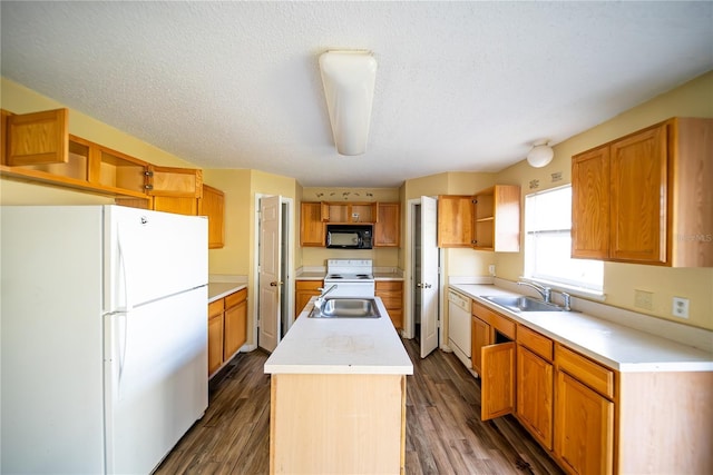 kitchen with a textured ceiling, a center island, white appliances, and sink