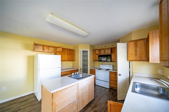 kitchen featuring sink, an island with sink, dark wood-type flooring, and white appliances