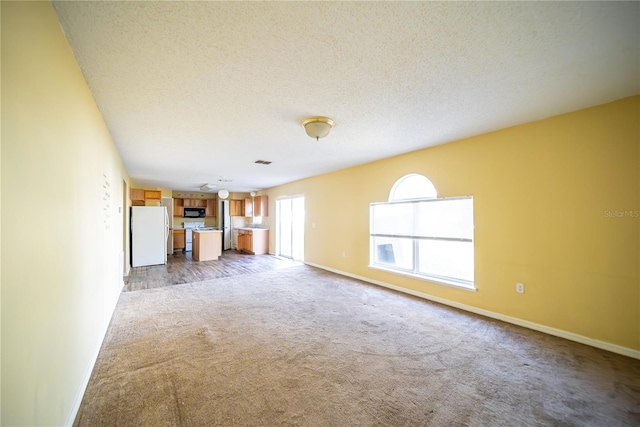 unfurnished living room with carpet and a textured ceiling