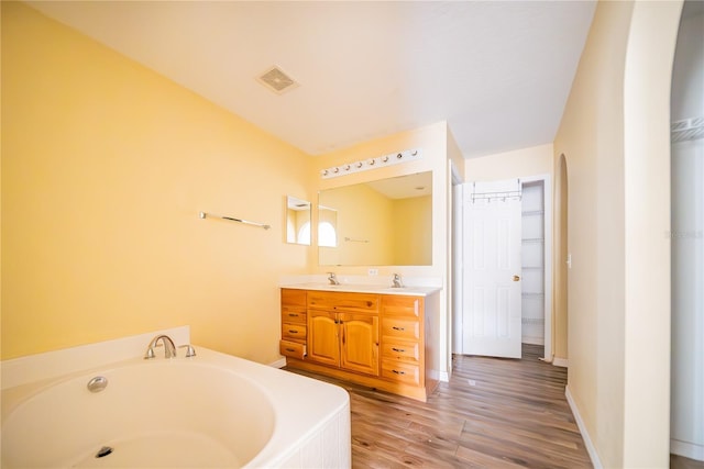 bathroom featuring a bathtub, vanity, and hardwood / wood-style flooring