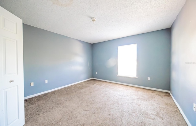 carpeted empty room with a textured ceiling