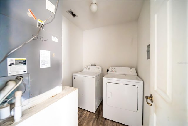 laundry area featuring washing machine and clothes dryer, heating unit, and dark hardwood / wood-style floors