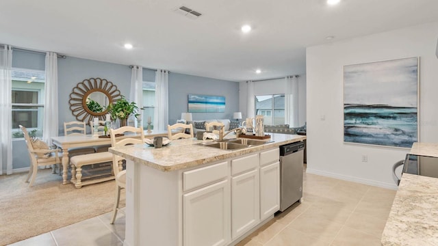 kitchen featuring dishwasher, a kitchen island with sink, white cabinets, sink, and light tile patterned floors