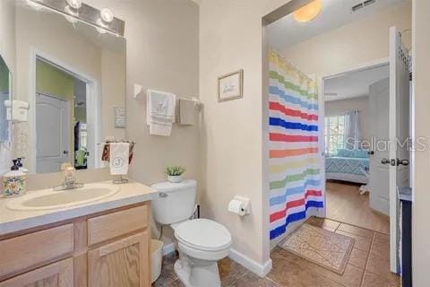 bathroom with tile patterned flooring, vanity, and toilet