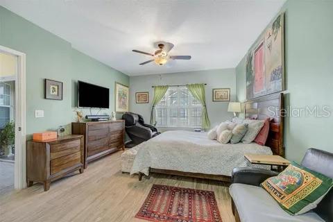 bedroom featuring access to exterior, light hardwood / wood-style floors, and ceiling fan