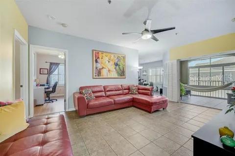 living room with ceiling fan and light tile patterned flooring