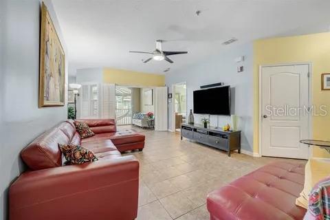 living room with light tile patterned floors and ceiling fan