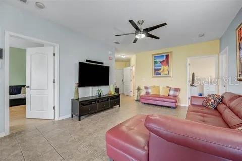 tiled living room with ceiling fan