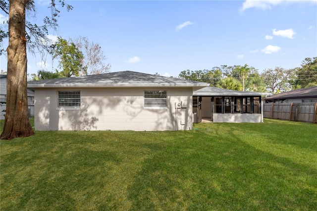 back of house with a sunroom and a yard