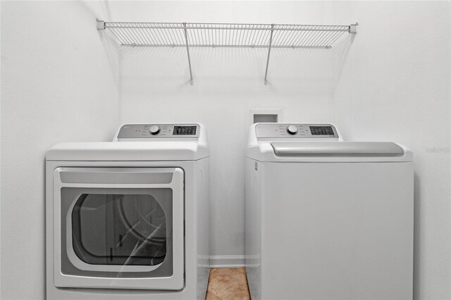 clothes washing area with tile patterned flooring and independent washer and dryer