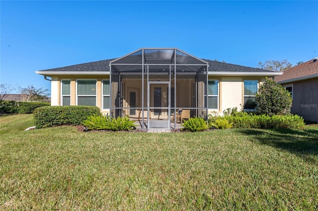 rear view of house with a lanai and a lawn