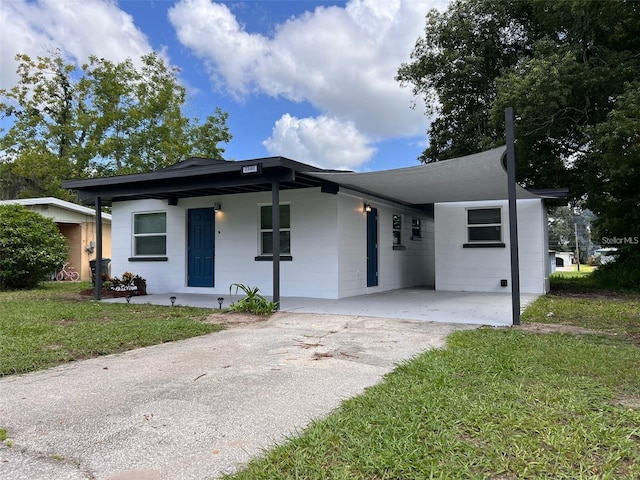 view of front of home featuring a carport, covered porch, and a front yard