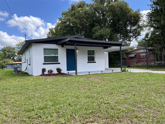 view of front of property with central AC and a front yard