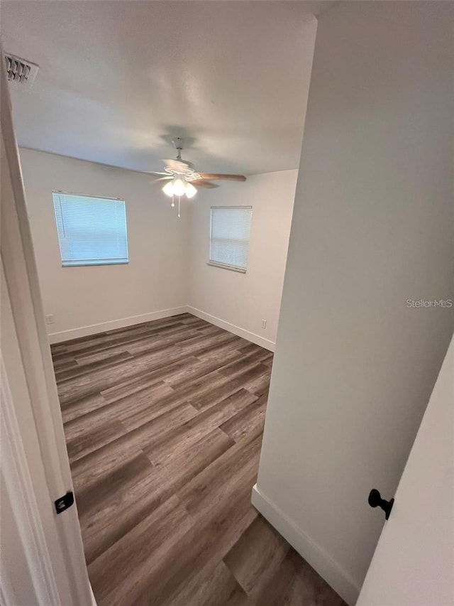 empty room featuring ceiling fan and dark wood-type flooring