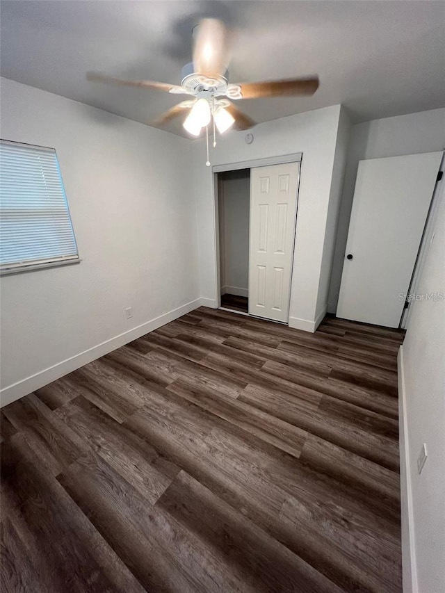 unfurnished bedroom with ceiling fan, dark hardwood / wood-style flooring, and a closet