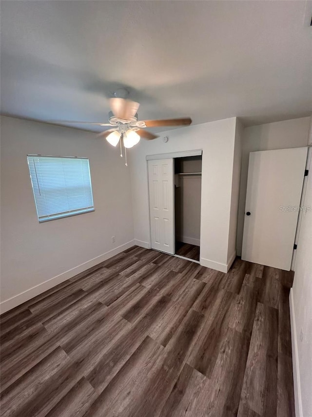 unfurnished bedroom with ceiling fan, a closet, and dark hardwood / wood-style floors