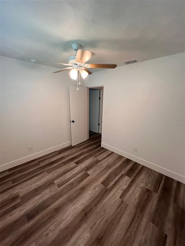 empty room with ceiling fan and dark wood-type flooring