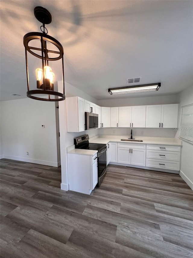 kitchen with dark hardwood / wood-style flooring, white cabinetry, black electric range, and decorative light fixtures