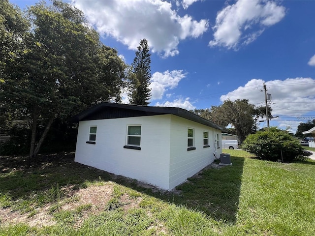 view of property exterior featuring central AC and a yard