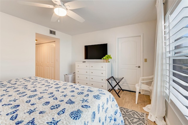 bedroom with a closet, light hardwood / wood-style flooring, and ceiling fan