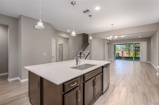 kitchen with dark brown cabinets, a kitchen island with sink, sink, dishwasher, and hanging light fixtures