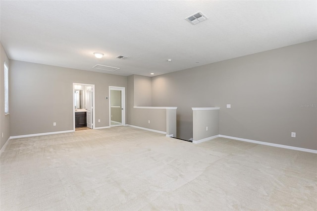 spare room with a textured ceiling and light colored carpet