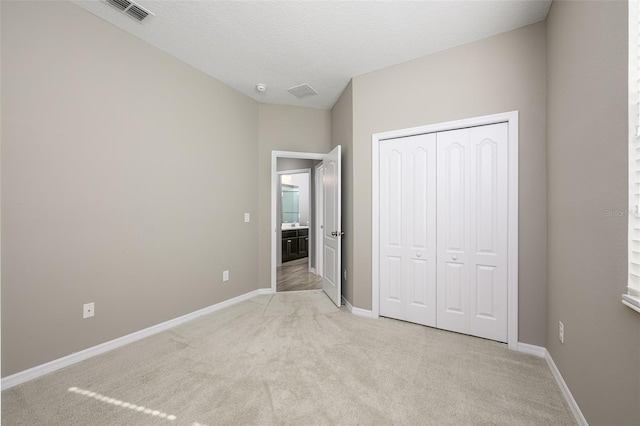 unfurnished bedroom with light carpet and a closet