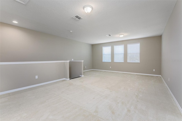 carpeted spare room featuring a textured ceiling