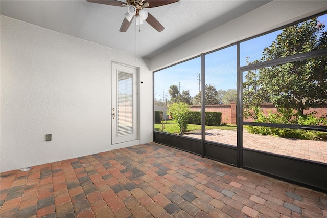 unfurnished sunroom featuring ceiling fan