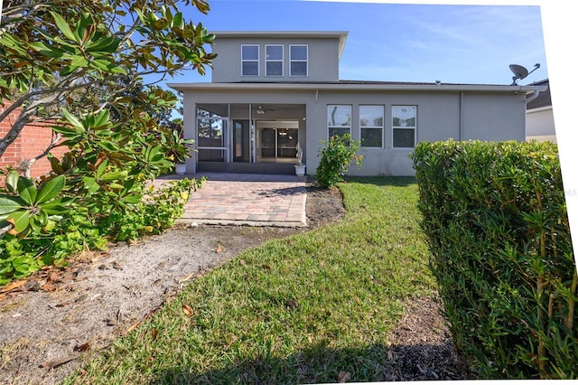 rear view of property with a yard and a sunroom