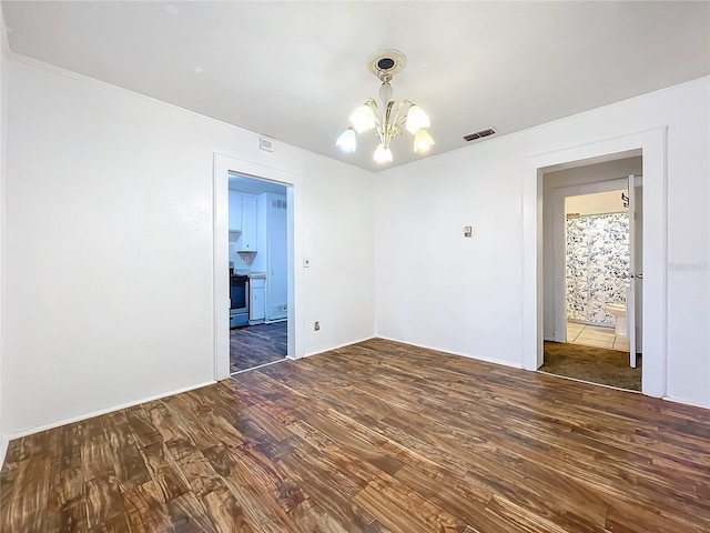 empty room featuring dark hardwood / wood-style flooring and a chandelier