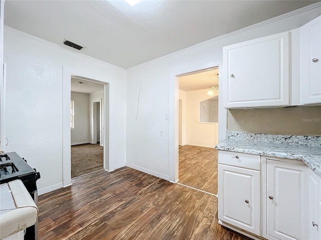 kitchen featuring tasteful backsplash, crown molding, dark hardwood / wood-style flooring, light stone countertops, and white cabinets