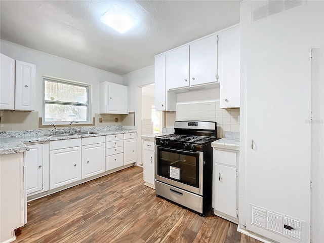 kitchen with gas range, sink, dark wood-type flooring, and white cabinets