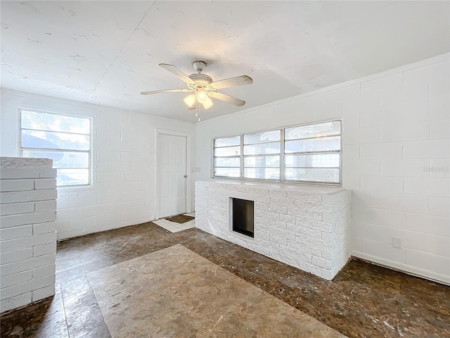 unfurnished living room featuring ceiling fan and a fireplace