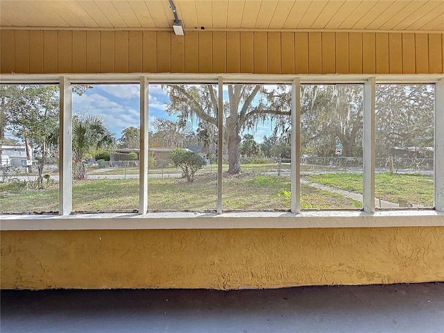 unfurnished sunroom featuring a healthy amount of sunlight and wooden ceiling