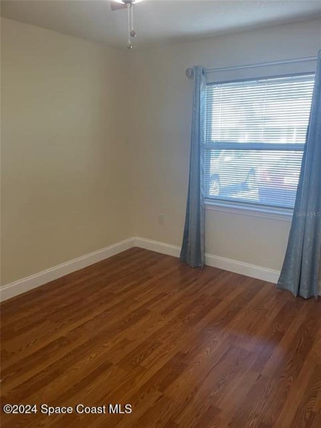 spare room with dark wood-type flooring