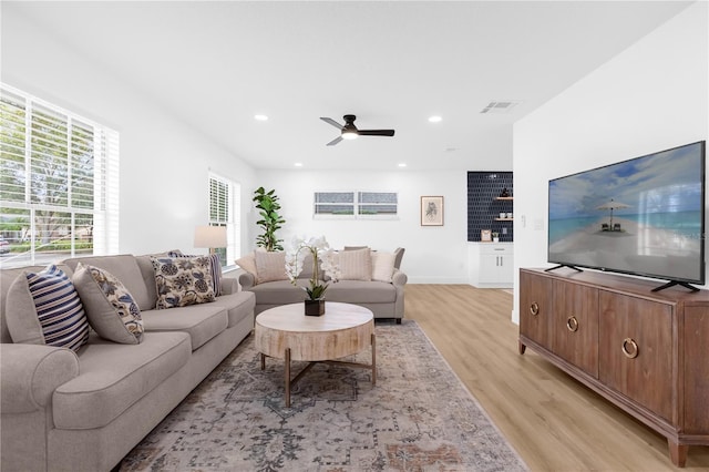 living room featuring light hardwood / wood-style floors and ceiling fan