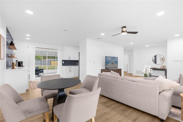 living room with ceiling fan and light wood-type flooring