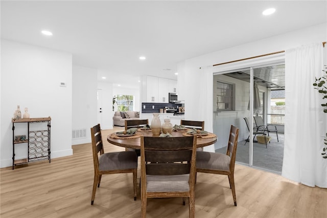 dining room featuring a healthy amount of sunlight and light hardwood / wood-style flooring