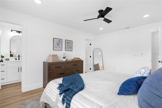 bedroom with light hardwood / wood-style floors, ensuite bath, ceiling fan, and sink