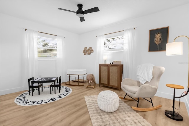 living area with hardwood / wood-style flooring and ceiling fan