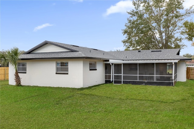 back of property with a lawn and a sunroom