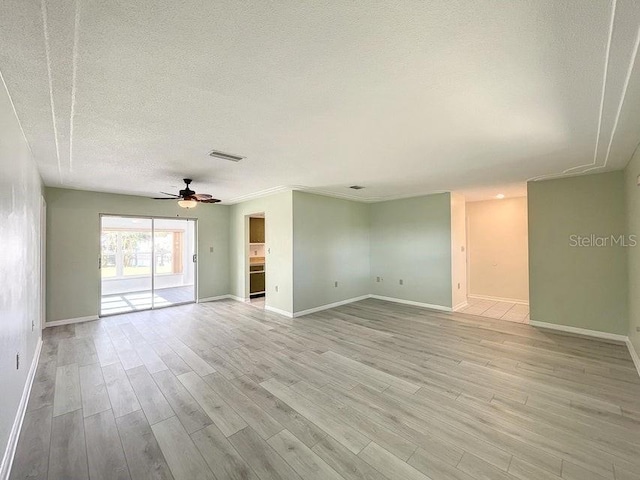 unfurnished room with ceiling fan, a textured ceiling, and light wood-type flooring