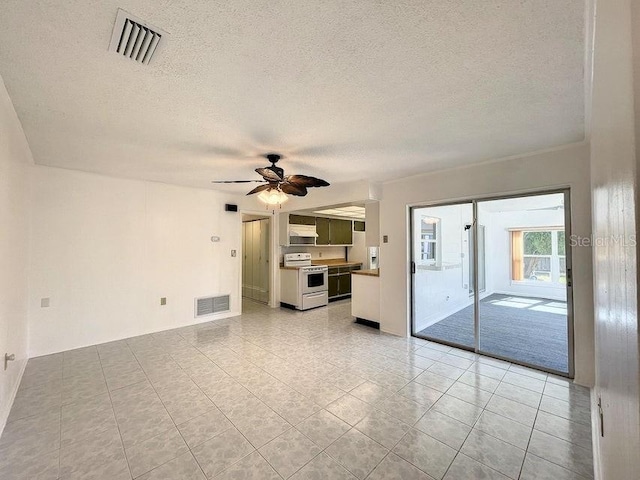 unfurnished living room featuring ceiling fan, light tile patterned floors, and a textured ceiling