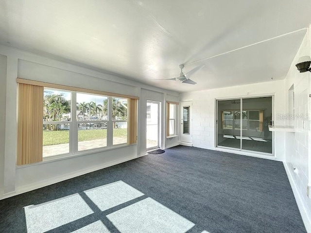 unfurnished sunroom featuring ceiling fan