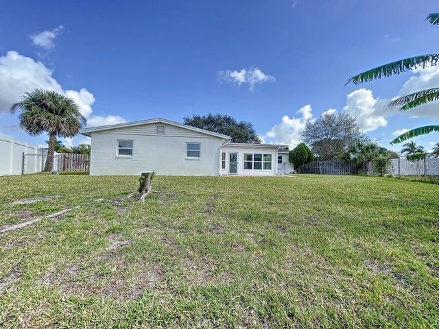 rear view of house featuring a lawn