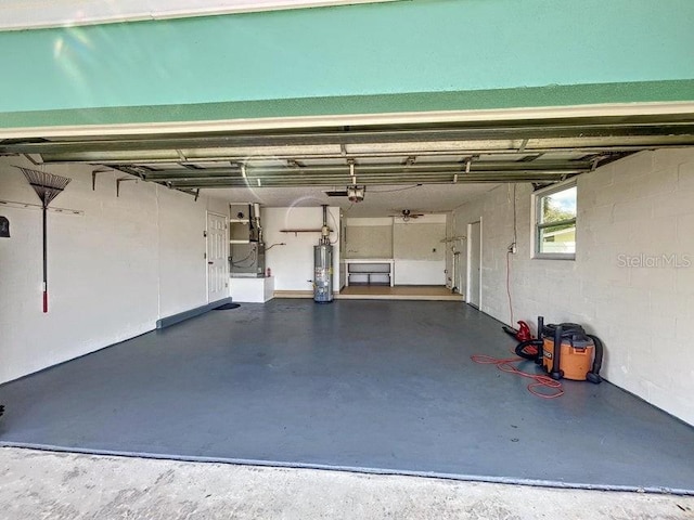 garage with gas water heater and a garage door opener