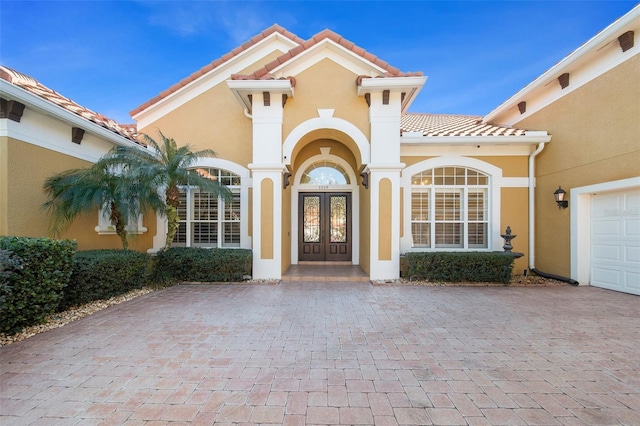 doorway to property with a garage and french doors