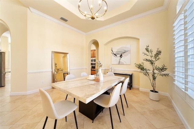 tiled dining room featuring a healthy amount of sunlight, a tray ceiling, crown molding, and a notable chandelier